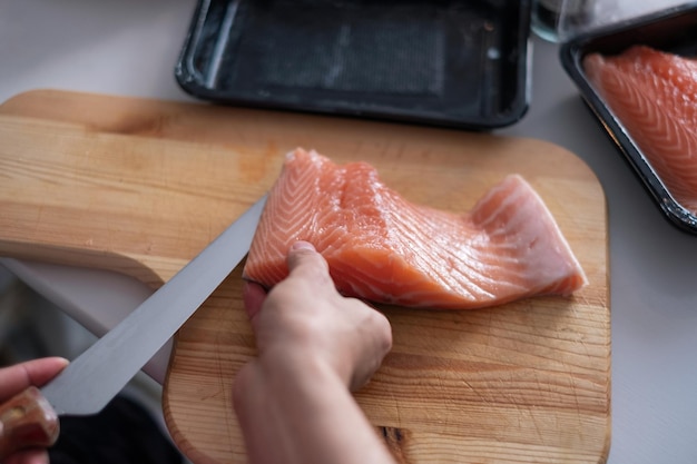 Mão, cozinheiro, usando, faca, fatia, cru, salmão, ligado, tábua cortante