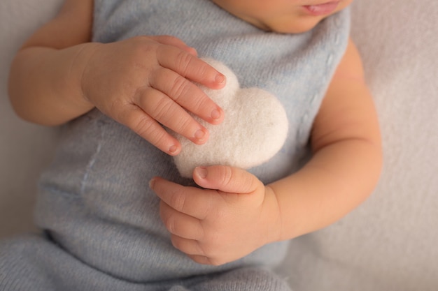 Mão da criança, dedos fecham. Mãos do bebê recém-nascido, conceito de infância feliz, saúde, fertilização in vitro, higiene. Recém-nascido com um coração mole nas mãos. Foto em preto e branco. Foto de alta qualidade