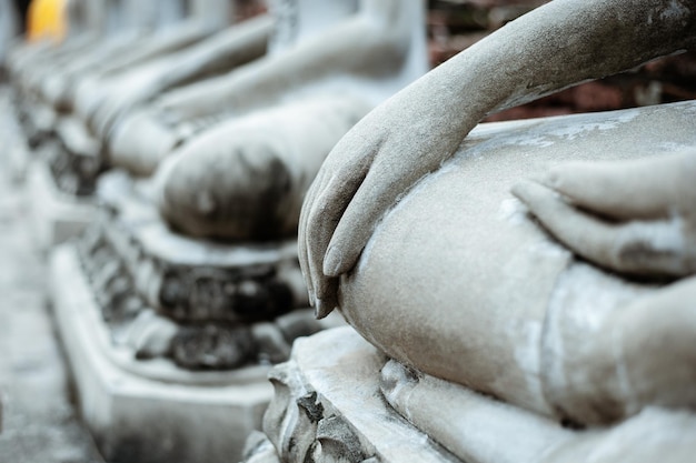 mão da estátua de Buda com luz amarela.