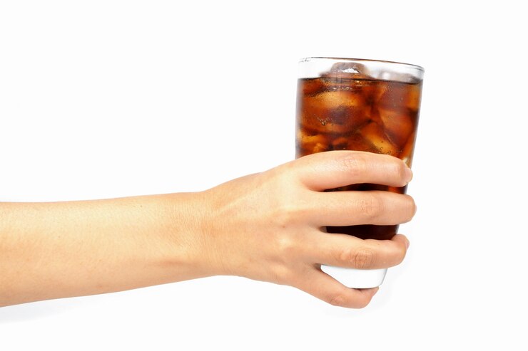 Foto mão da menina segurando um copo de coca-cola com gelo
