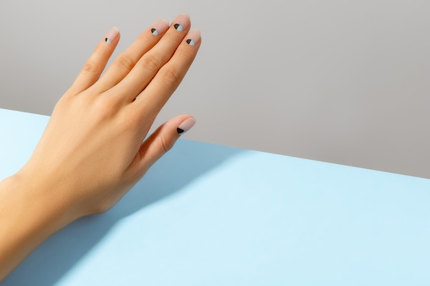 Mão da mulher bonita preparada com design de unhas matte nude e azul. conceito de salão de beleza de manicure e pedicure.