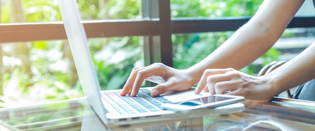 Mão da mulher de negócio que trabalha com um computador portátil no escritório.