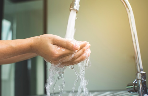 Mão da mulher que lava com sabão antibacteriano para contra o conceito da higiene dos germes de infecção.