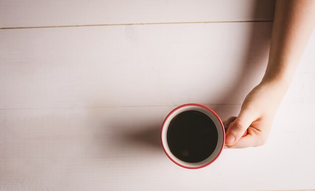 Mão da mulher segurando a xícara de café