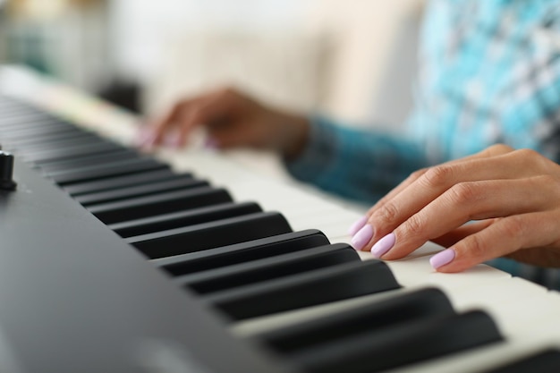 Mão da mulher tocando teclados brancos e pretos no piano