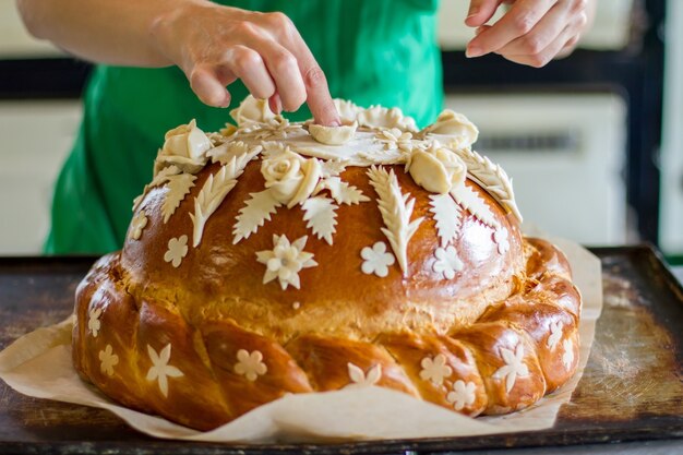 Mão da senhora tocando pastelaria decorada. Pão na bandeja. Pão de casamento lindo. Mantenha-se fiel às tradições.