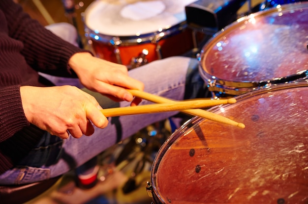 Mão de baterista com baquetas e bateria