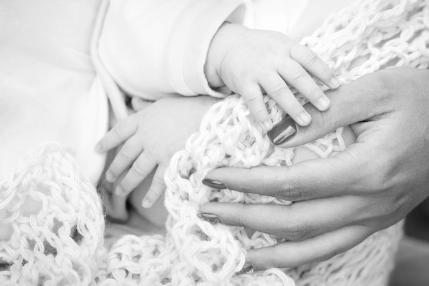 Mão de crianças recém-nascidas na mão da mãe Mãe e seu filho conceito de família feliz