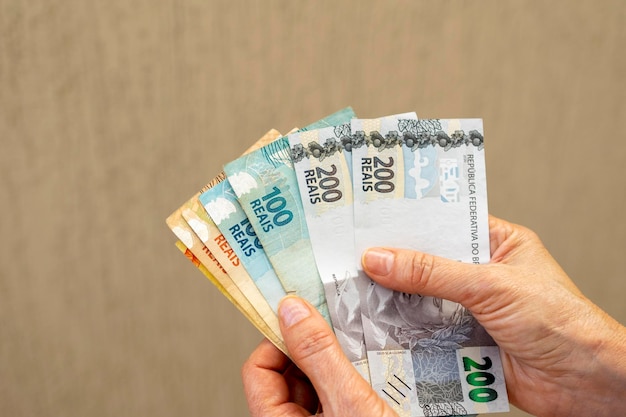 Mão de dinheiro do brasil segurando notas brasileiras