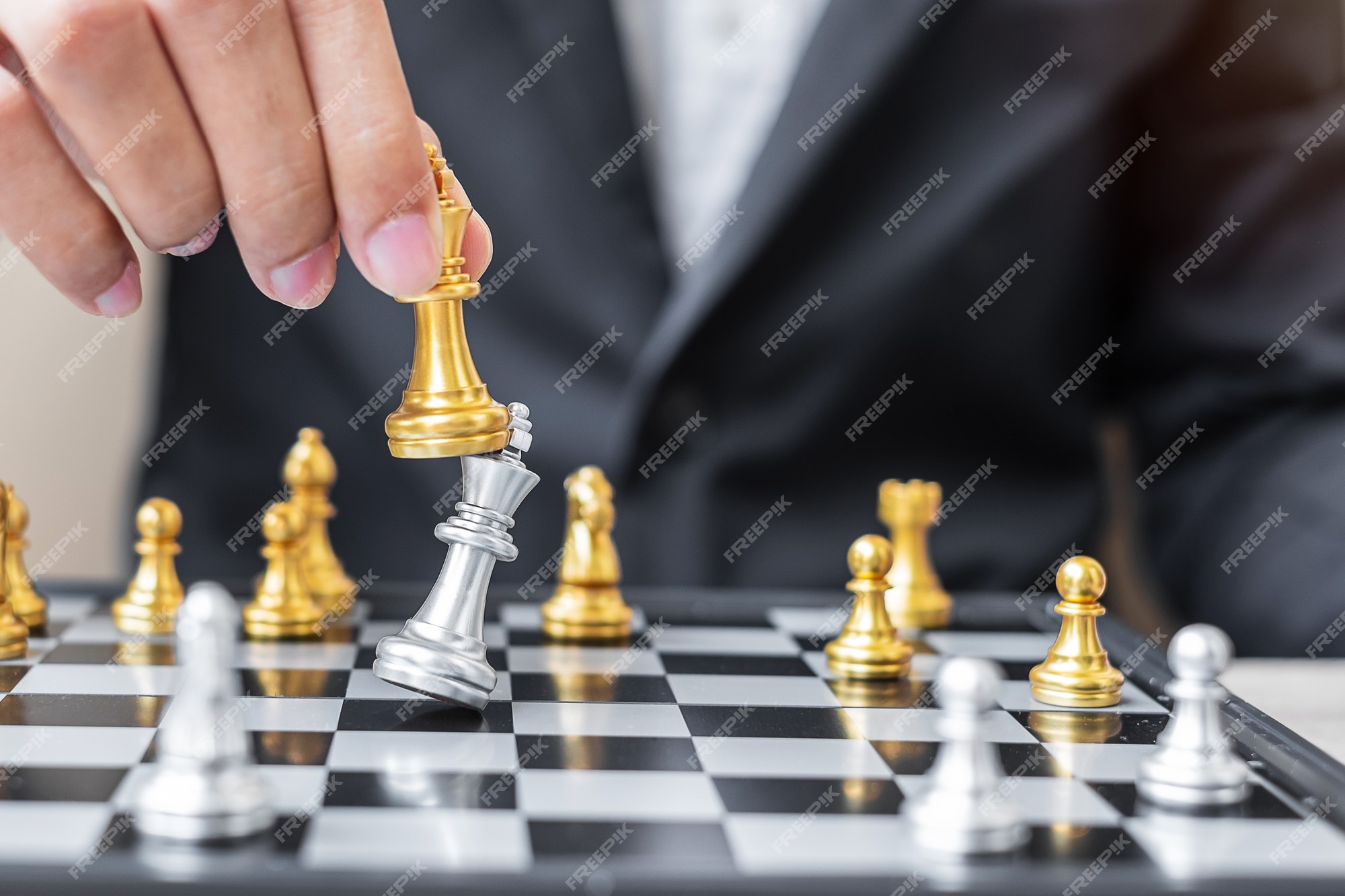 Mãos de empresário movendo o rei do xadrez para a posição de sucesso no  jogo de competição de negócios