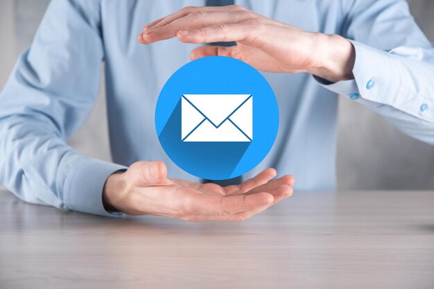 Mão de empresário segurando o ícone de carta, ícones de e-mail. Entre em contato conosco por e-mail de boletim informativo e proteja suas informações pessoais de spam. Call center de atendimento ao cliente entre em contato conosco.