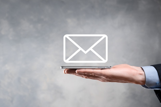 Mão de empresário segurando o ícone de e-mail, entre em contato conosco por e-mail de boletim informativo e proteja suas informações pessoais de mensagens de spam