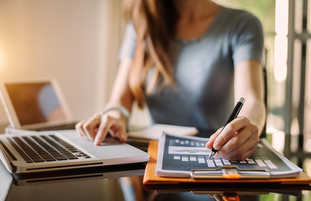 Mão de empresário trabalhando com novo computador moderno e escrevendo no diagrama de estratégia do bloco de notas como conceito