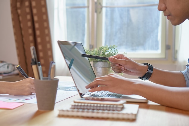 Mão de empresário trabalhando laptop na mesa de madeira