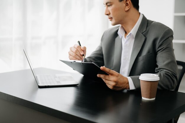 Mão de empresário usando laptop e tablet de telefone inteligente com diagrama de rede social na mesa como conceito na luz da manhã