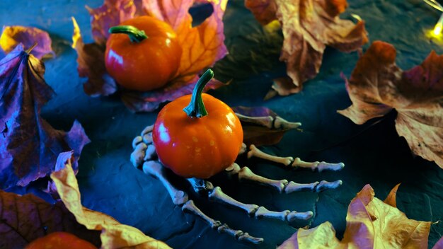 Mão de esqueleto de fundo de Halloween com abóbora decorativa