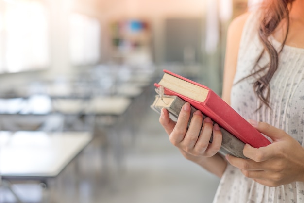 mão de estudante segurar livro para leitura na biblioteca da Universidade