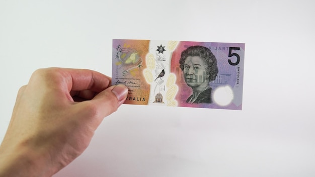 Mão de homem asiático segurando um dólar australiano isolado no fundo branco