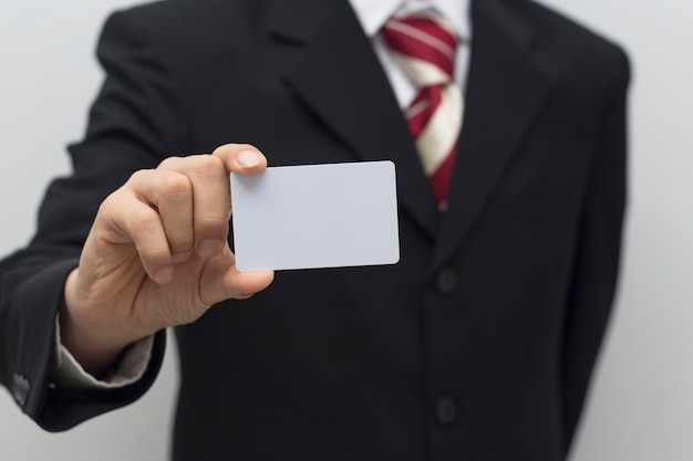 Mão de homem de negócios segurando o cartão branco