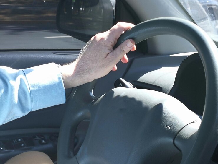 Foto mão de homem irreconhecível no volante de carros