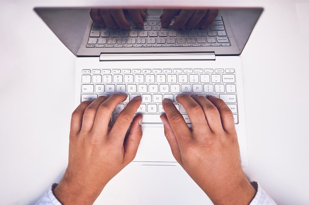 Foto mão de homem no teclado do laptop