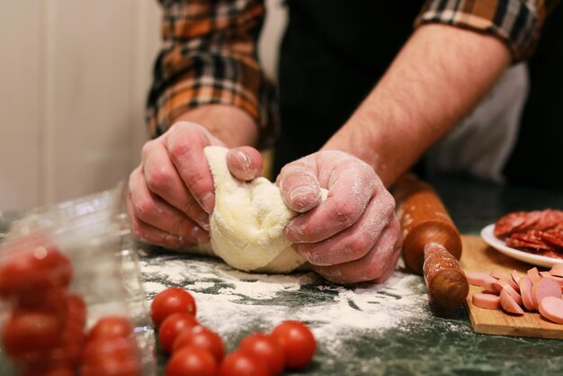 Mão de homem preparar cobertura de massa de pizza