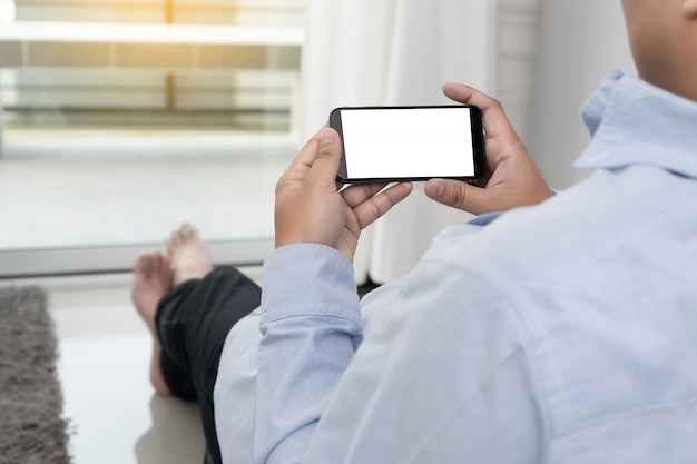 Mão de homem segurando a maquete de tela do smartphone preto