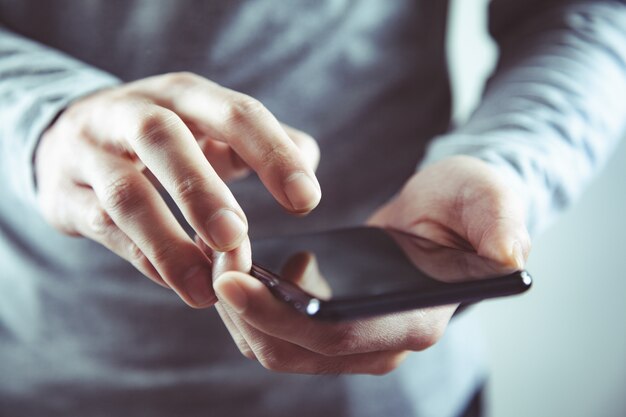 Mão de homem segurando telefone inteligente