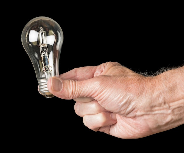 Mão de homem segurando uma lâmpada halógena em breve será proibida na UE