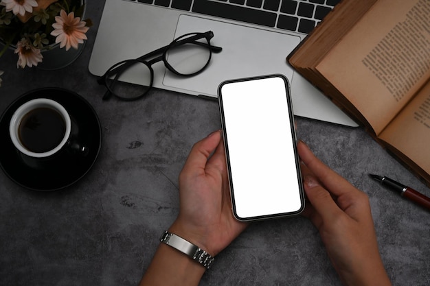 Mão de jovem segurando o telefone inteligente com tela vazia para propaganda