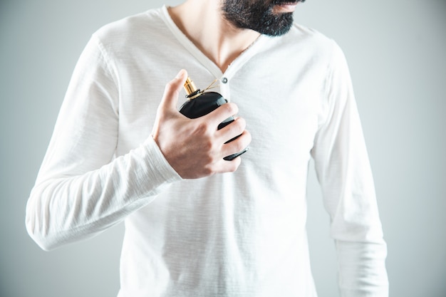 Mão de jovem segurando perfume