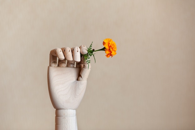 mão de madeira segurando uma flor
