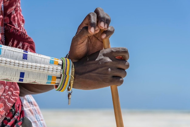 Mão de masai tribal com uma pulseira colorida na praia de areia perto do mar na ilha Zanzibar Tanzânia África Oriental fechar