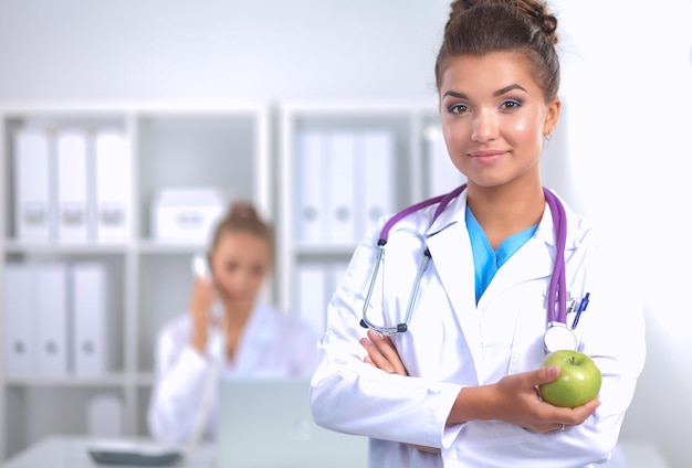 Foto mão de médica segurando uma maçã verde