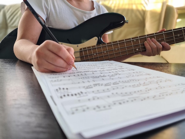 Mão de menina compositora escrevendo notas no caderno fechado