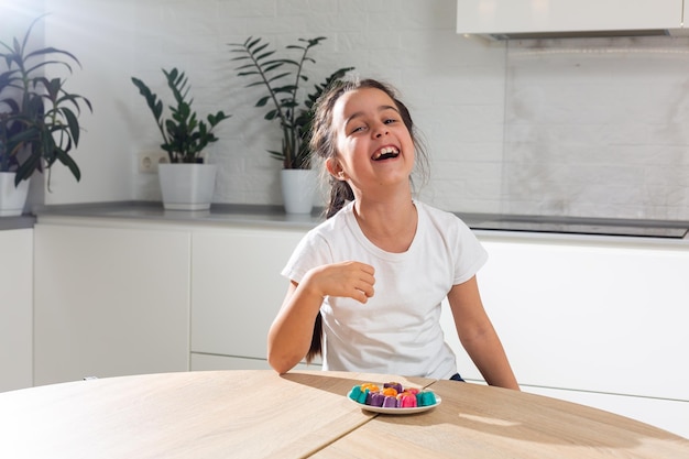 Mão de menina decorando doces caseiros.