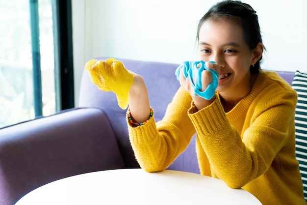 Foto mão de menina segurando um brinquedo caseiro chamado slime,