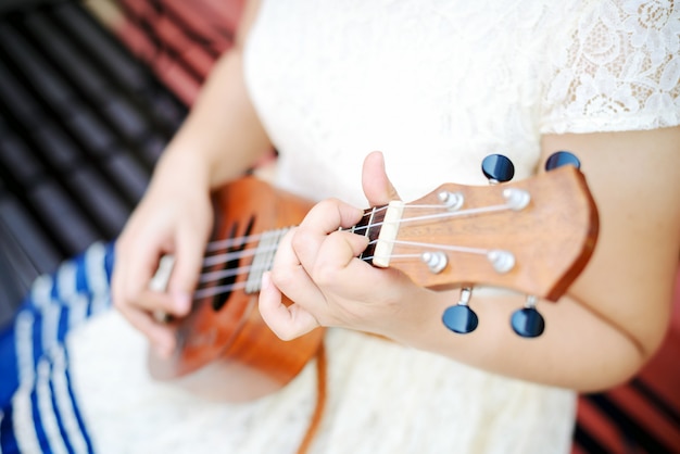 Mão de menina tocando ukulele