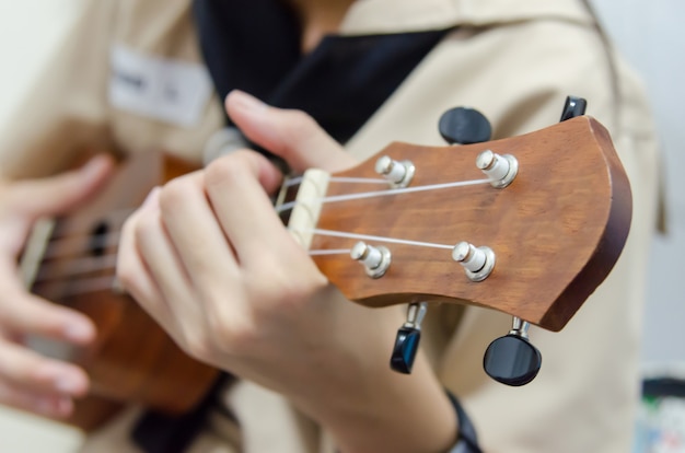 Mão de menina tocando ukulele