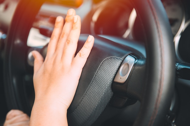 Foto mão de motorista de mulheres closeup no chifre de volante dentro do tom de cor vintage de carro