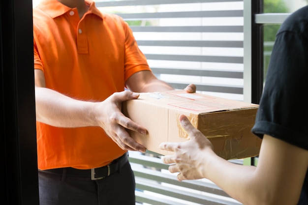 Mão de mulher aceitando uma entrega de caixas de entregador