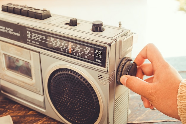 Mão de mulher, ajustando o botão vintage rádio