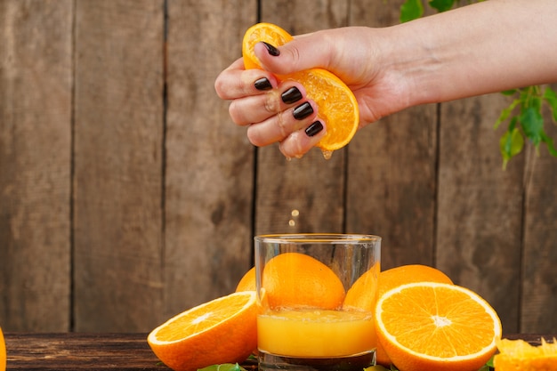 Mão de mulher aperta suco de laranja close-up