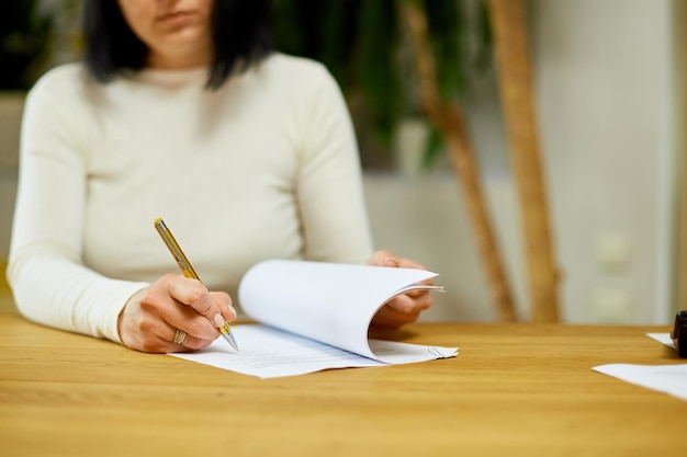 Mão de mulher assinando um contrato fazendo um acordo com o parceiro de negócios