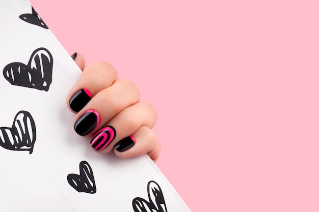 Mão de mulher bonita bem cuidada com manicure na moda rosa