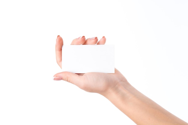 Mão de mulher com uma folha de papel branca na palma da sua mão isolada no fundo branco