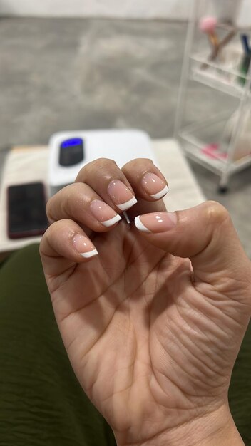 Foto mão de mulher com unha francesa design de unhas clássico de tendência