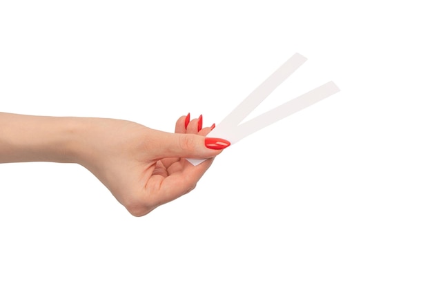 Mão de mulher com unhas vermelhas com tiras de teste para o perfume isolado em um fundo branco