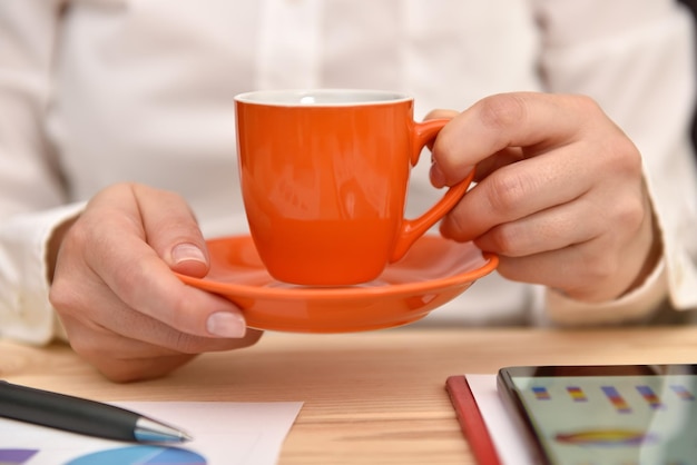 Mão de mulher com xícara de café