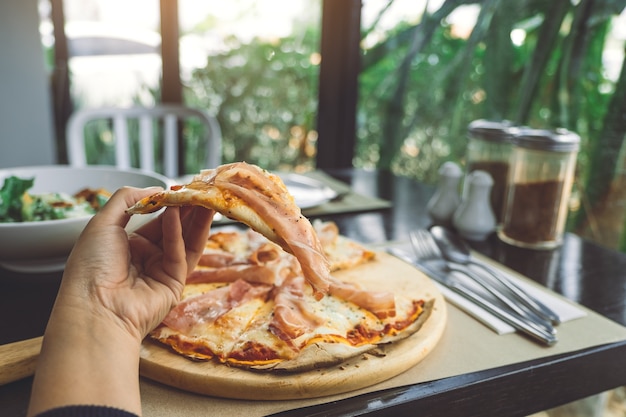 Mão de mulher comer com pizza